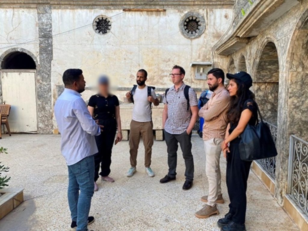 Ahmed Mohammed, founder of Volunteer with Us, Dr Rajan Basra, Dr Craig Larkin, Ayoub Thanoon from Mosul Heritage House, and Dr Inna Rudolf stand outside the Volunteer with Us headquarters