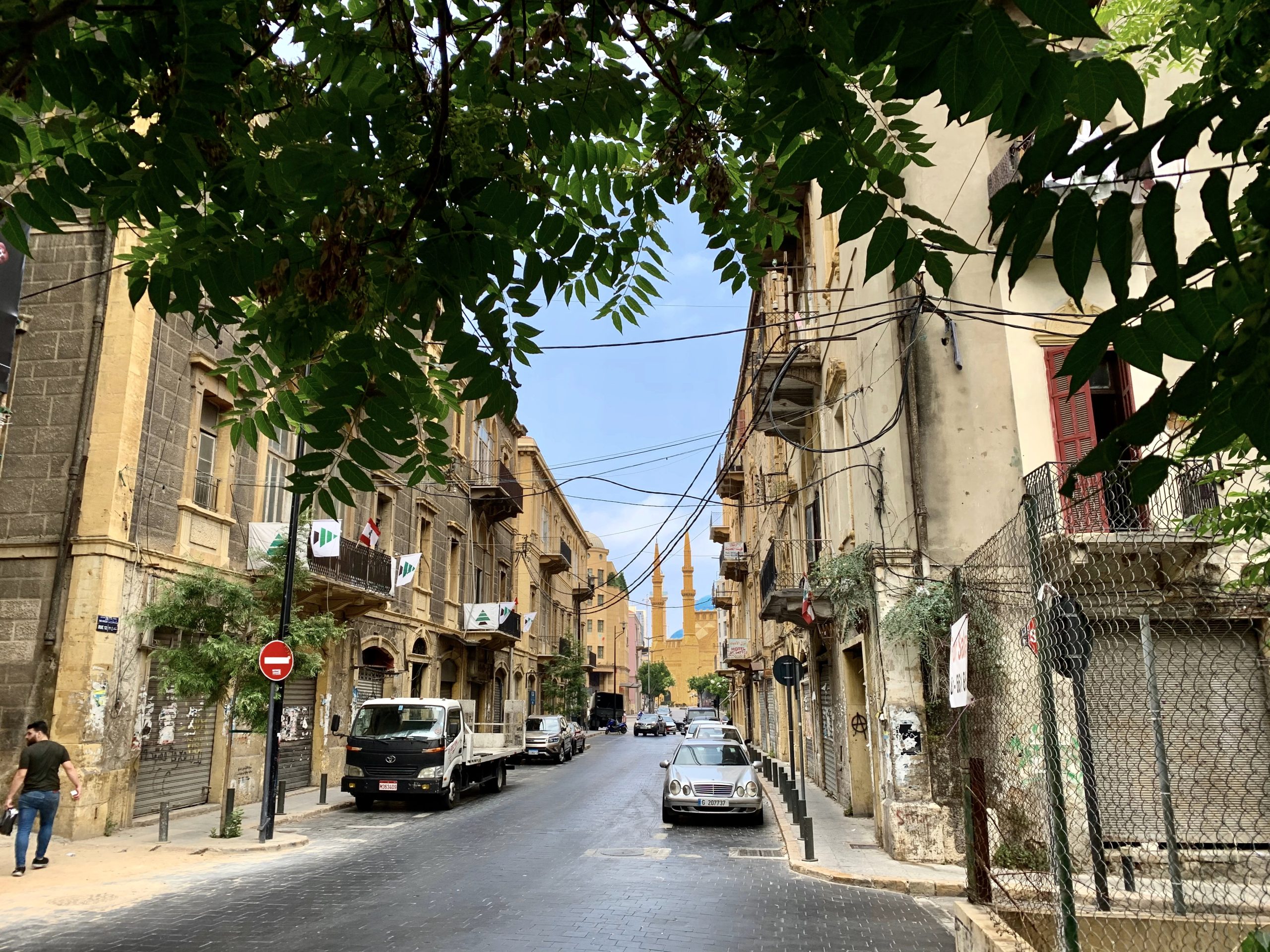 A building-lined road leading to a mosque