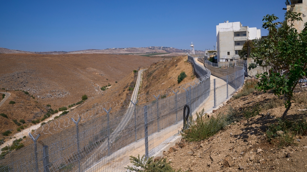 View of Lebanon as seen from Ghajar, a disputed village located on the border between Lebanon and Golan Heights of Israel. A large barbed wire fence stands at the border