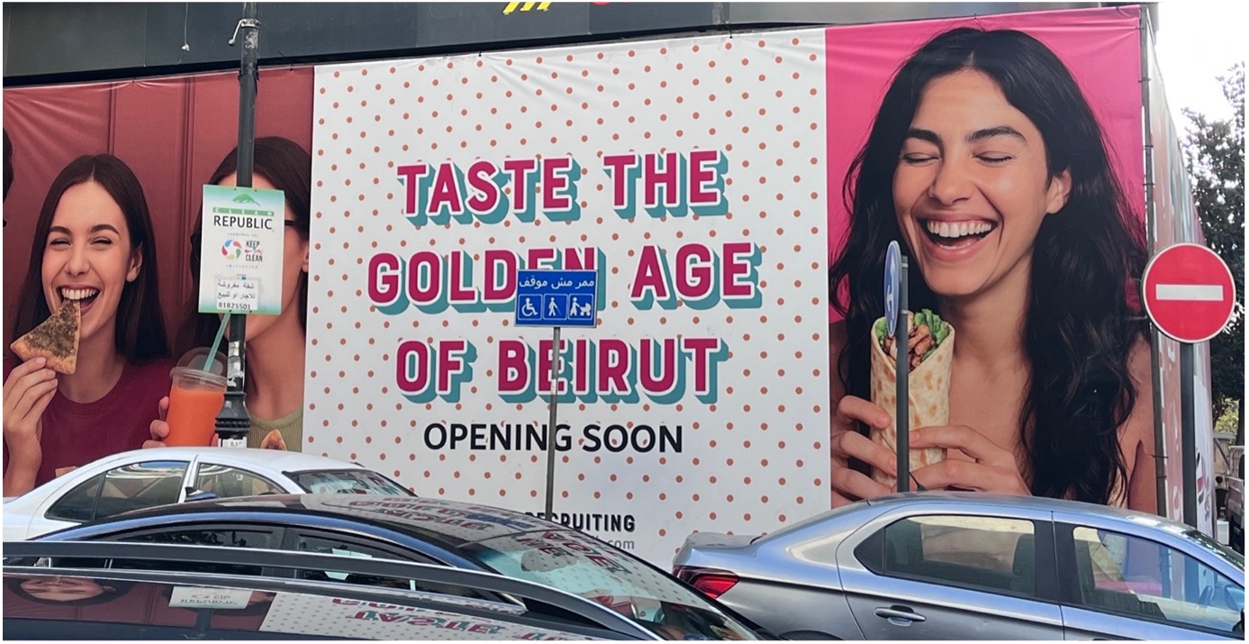 A poster depicting the words 'Taste the Golden Age of Beirut. Opening soon' and two images of women eating