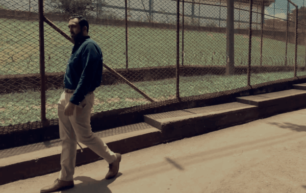 man walking in front of secure fencing